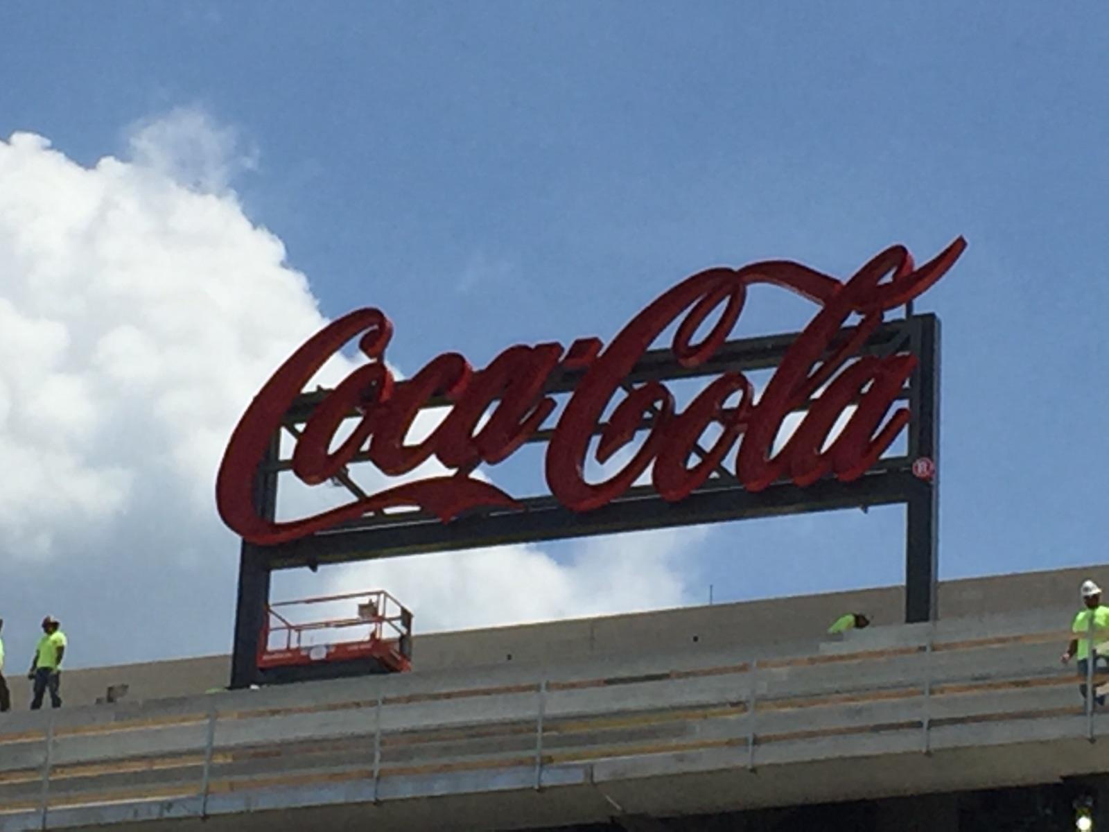Large-scale Coca-Cola sign installed on a building rooftop